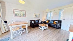 a living room with a couch and a table at Nantucket Cottage - Part of the The Bay Filey Holiday Village with pool, gym and direct beach access, pub, restaurant, tennis and meadows walks in Filey