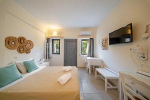 a room with a bed and a couch and a tv at Ersi Villas in Firostefani