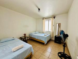 a room with two beds and a fan at Casita Iluminada in Oaxaca City