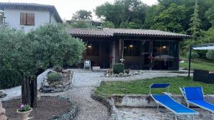 a house with two blue chairs in a yard at La Collina Dei Castagni in Terni