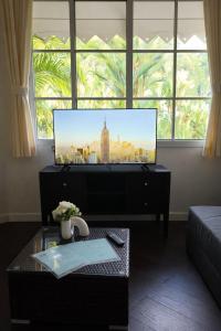 a living room with a flat screen tv and a table at Caribbean Hill Villas in Cocles