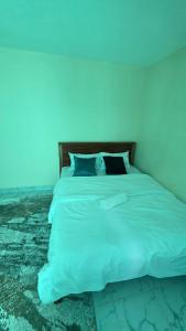 a bedroom with a white bed with blue lights at EasyNest in Kinoo