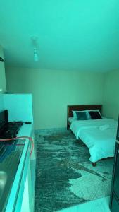 a bedroom with two beds and a blue light at EasyNest in Kinoo
