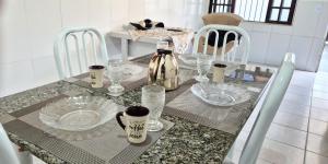 a dining room table with plates and glasses on it at STO01 - Casa ampla em bairro tranquilo do Guarujá in Guarujá