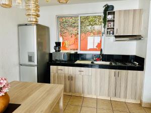 a kitchen with wooden cabinets and a window and a table at Casita Iluminada in Oaxaca City