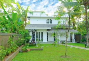 a white house with a garden in front of it at Villa Mario in Unawatuna