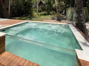 a large pool of water with a wooden deck at Hotel Pousada Pitinga in Arraial d'Ajuda