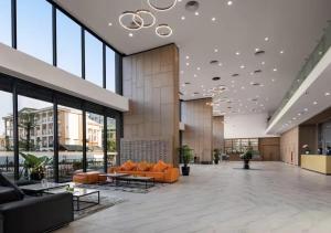 a lobby with orange furniture and large windows at PentStudio Westlake - Cozy Duplex - New Apartment in Hanoi +23 photos