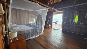 a bedroom with a bed and a wooden floor at Yonas Homestay - Raja Ampat in Besir