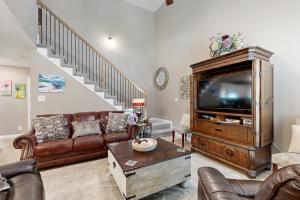 a living room with a television and leather furniture at Gateway to Fort Campbell! Home w/ Furnished Deck in Clarksville