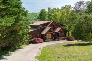 a log cabin in the woods with a driveway at Hot Tub + Dock! Waterfront Norris Lake Log Home in Elm Springs