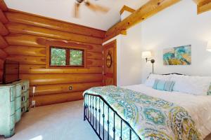 a bedroom with a bed and a wooden wall at Hot Tub + Dock! Waterfront Norris Lake Log Home in Elm Springs