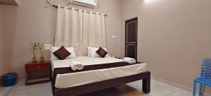 a bedroom with a bed with white sheets and a window at Sukra Residency in Valavanūr +76 photos