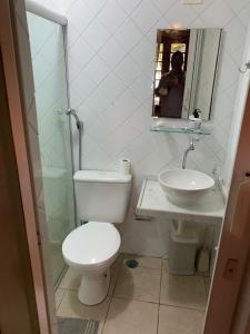 a man taking a picture of a bathroom with a toilet and sink at Chalé Gravatá 2022 in Gravatá +18 photos