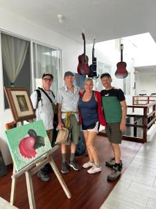 a group of people standing in a room with a painting at Marina Suite in Puerto Ayora