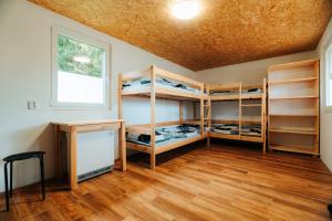 a room with bunk beds and a desk and a window at Růžená - chatky u rybníka in Milevsko