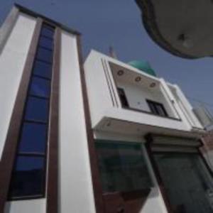 a white building with a window on top of it at Jai Shree Ram hotel in Ayodhya