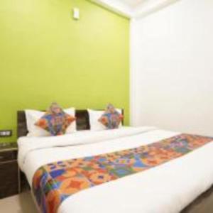 a bed in a room with a green wall at Jai Shree Ram hotel in Ayodhya +28 photos