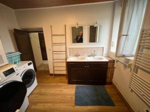 a person taking a picture of a bathroom with a sink at Lou Castel in Le Clapier +26 photos