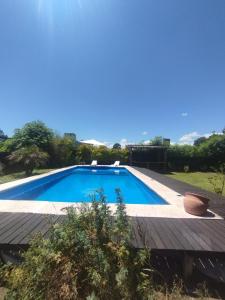 a swimming pool in a yard with a wooden deck at ParaisolaRinconada in La Porteña