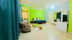 a room with a bed and a couch and a television at WELCOME LODGE in Ouagadougou