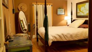 a bedroom with a bed and a mirror and a table at Artist Chalet in Flagstaff