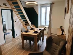 a dining room with a table and chairs and a staircase at Au 24 a connerre in Connerré