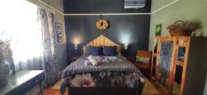 a bedroom with a large bed with blue walls at Die Pophuis in Aberdeen