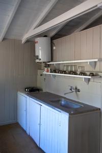 a kitchen with blue cabinets and a sink at Bungalow Caravan in Villa Gesell