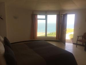 una camera da letto con un letto e vista sull'oceano di Questel BronQ a Chã da Igreja