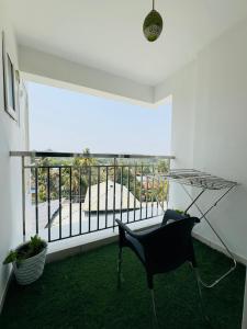 a black chair in a room with a balcony at Haven by Glass Loft-Premium 2BHK near KIMS and GG Hospital in Trivandrum