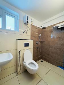 a bathroom with a toilet and a phone on the wall at Haven by Glass Loft-Premium 2BHK near KIMS and GG Hospital in Trivandrum +6 photos