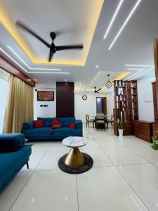 a living room with a blue couch and a ceiling fan at Haven by Glass Loft-Premium 2BHK near KIMS and GG Hospital in Trivandrum