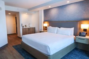 a bedroom with a large white bed with a blue wall at Miccosukee Casino & Resort in Miami