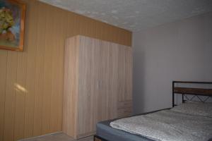a bedroom with a bed and a wooden cabinet at Ferienwohnug Home in Gotha