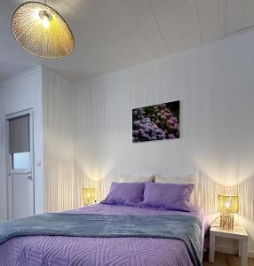 a bedroom with a purple bed and two lamps at Raiz Atlântica in Angra do Heroísmo