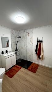 a bathroom with a shower and a toilet and a sink at Raiz Atlântica in Angra do Heroísmo +24 photos