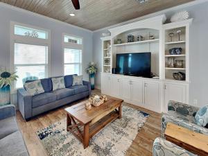 a living room with a couch and a tv at Postcard from Paradise in Padre Island +48 photos