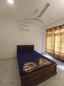 a bedroom with a bed in a room with windows at Villa Anu in Hikkaduwa