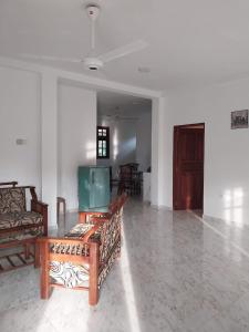 a living room with couches and a tv in it at Villa Anu in Hikkaduwa