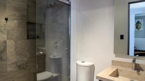 a bathroom with a shower and a toilet and a sink at Casa Solsticio 212 in Cholula +25 photos