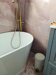 a bathroom with a white bath tub and a toilet at Room FULHAM TF2 in London +1 photo