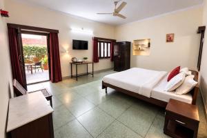a bedroom with a bed and a desk and a television at Hotel Gajender Niwas Sun City A Boutique Stay in Jodhpur