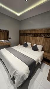 a bedroom with a large bed with white sheets at شقق الدار in Jeddah