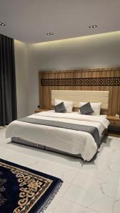 a bedroom with a large white bed with a headboard at شقق الدار in Jeddah +13 photos