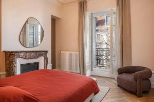 a bedroom with a bed and a mirror and a chair at Le Dubedout - Hyper Centre - Bastille in Grenoble