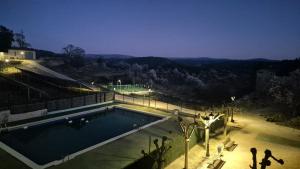 a swimming pool at night with people standing around it at Hostal Restaurante Portell in Portell de Morella