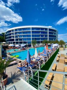 a hotel with a pool and chairs and a building at Sea Pearl 1Line in Odesa