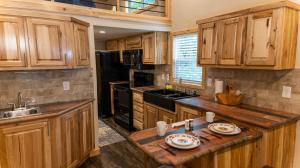 a kitchen with wooden cabinets and a black refrigerator at Moon River Ranch in Satin