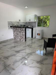 a kitchen with a marble floor and white walls at Brisas del mar in Santa Cruz de Barahona